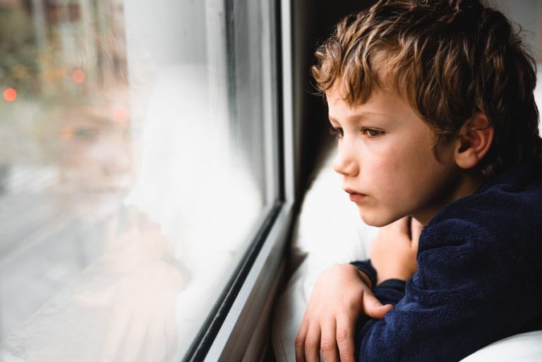 sad child staring out a window