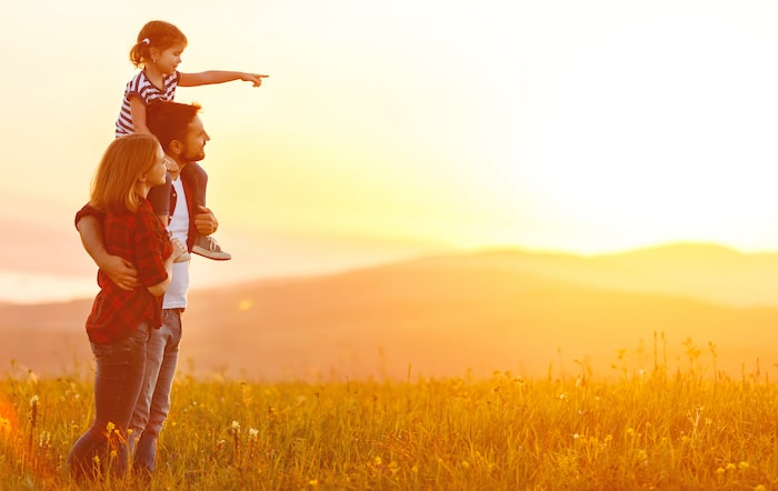 son on dads shoulder at sunset