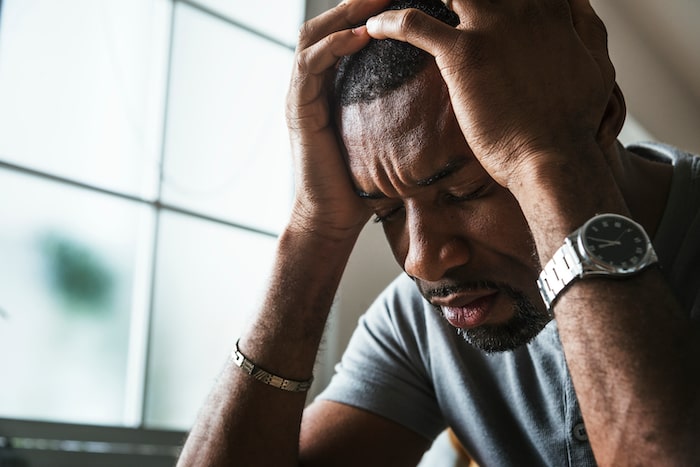 upset black man hands on his head