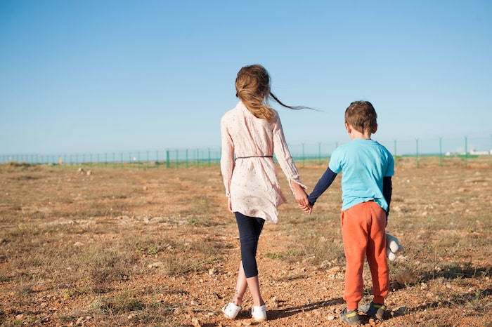 boy and girl holding hands in field