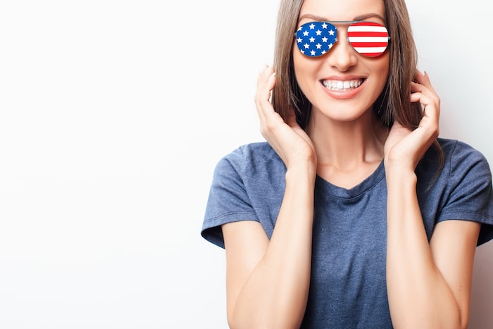 woman smiling with american flag glasses