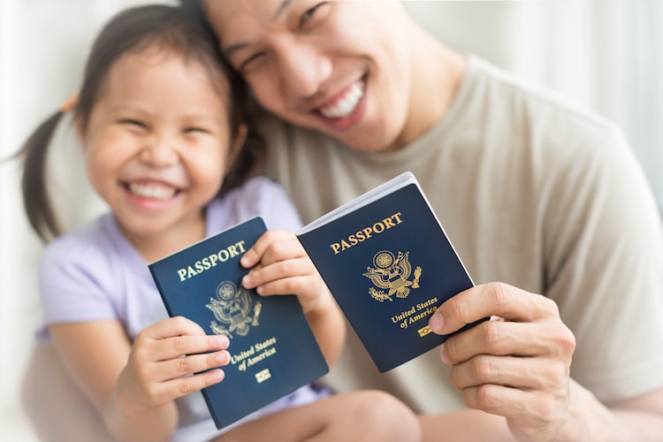 dad and daughter smiling with passports